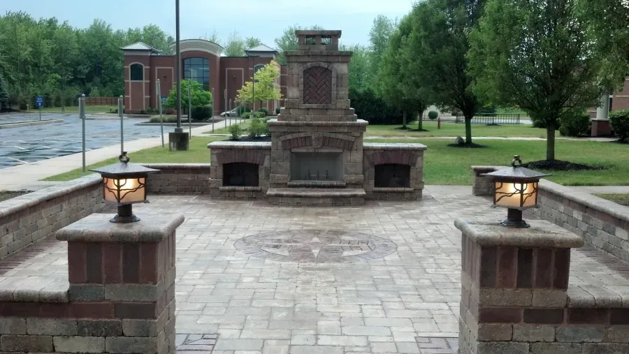 A brick patio with a fireplace in the middle of it