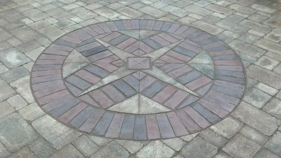 A circular design made of bricks on a patio