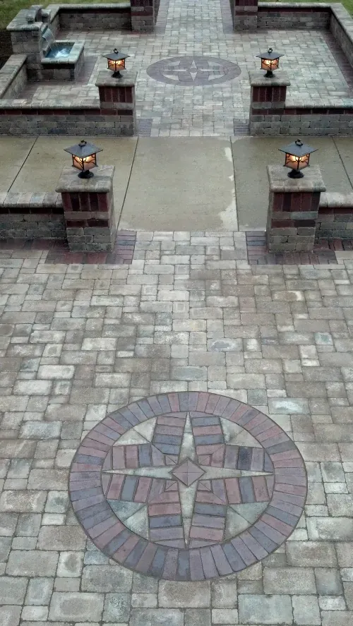An aerial view of a brick patio with a circular design in the middle.