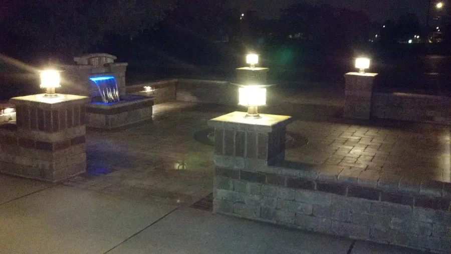 A fountain is lit up at night in a park