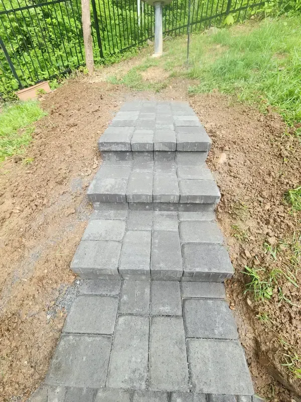 A walkway made of bricks is going up a hill.