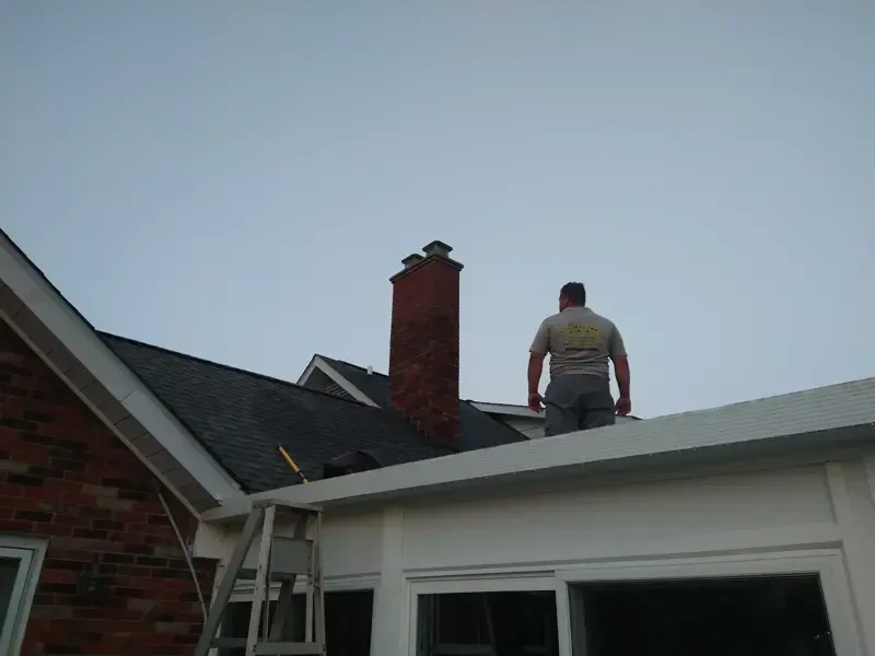 A man is standing on the roof of a house