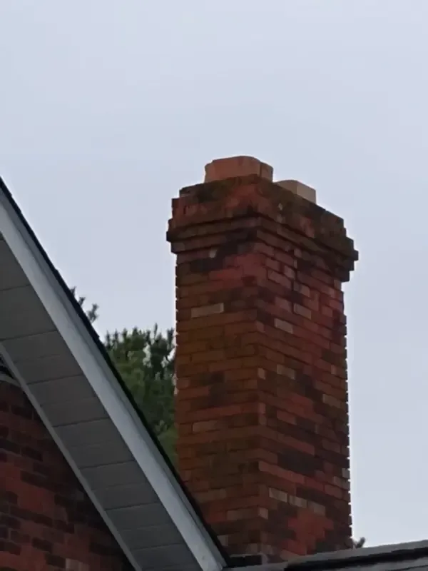 A brick chimney on top of a brick house