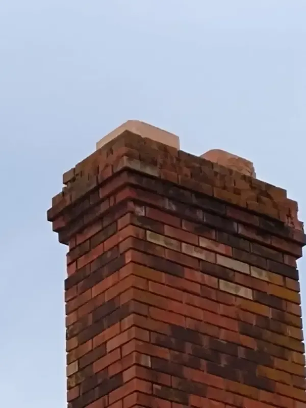 A brick chimney with a blue sky in the background