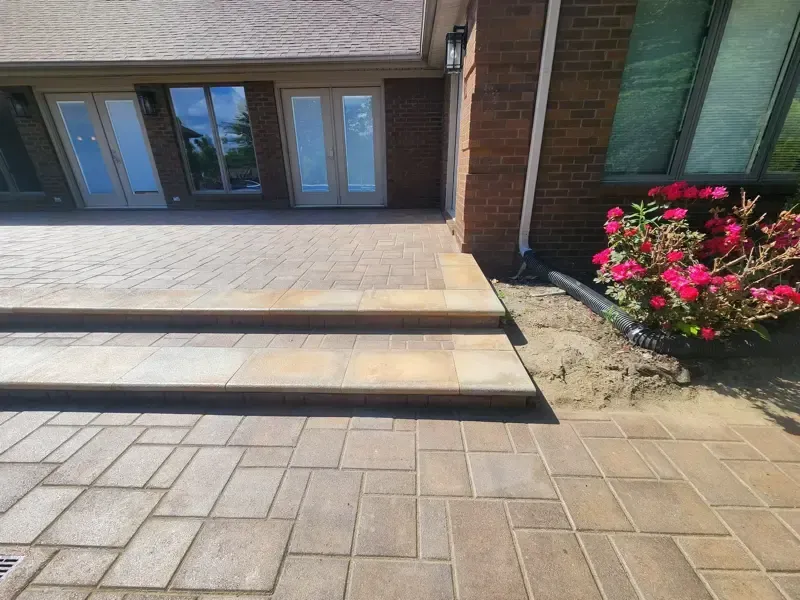 A brick walkway with steps leading up to a brick house.