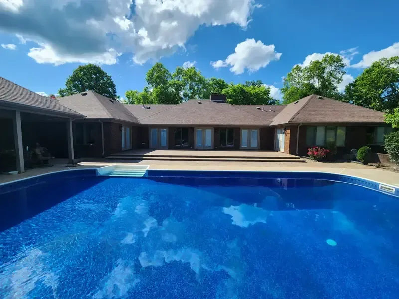 A large house with a large swimming pool in front of it