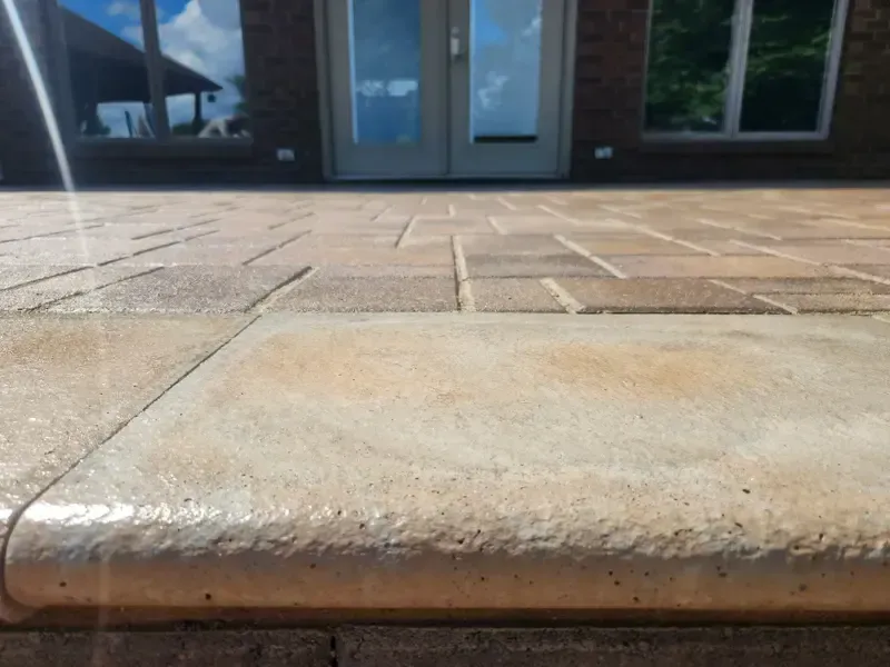 A close up of a brick walkway with a door in the background.