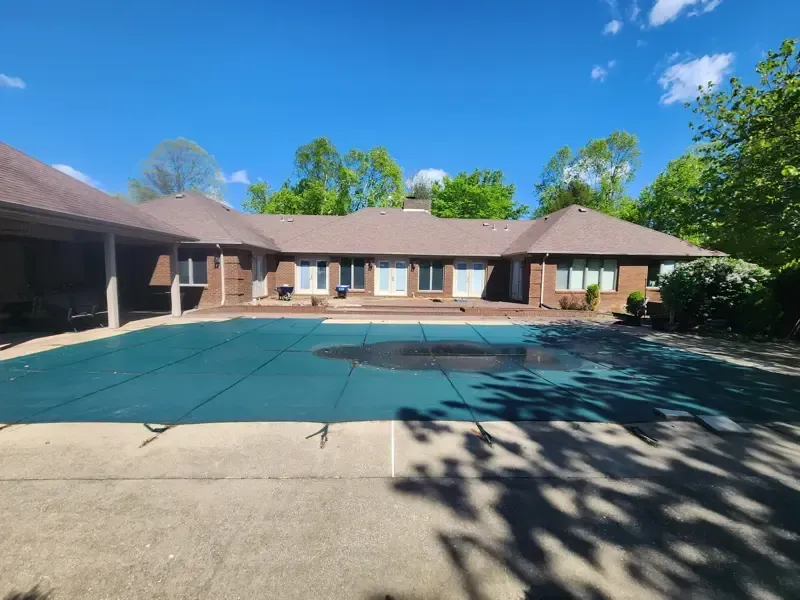 A large house with a swimming pool in front of it