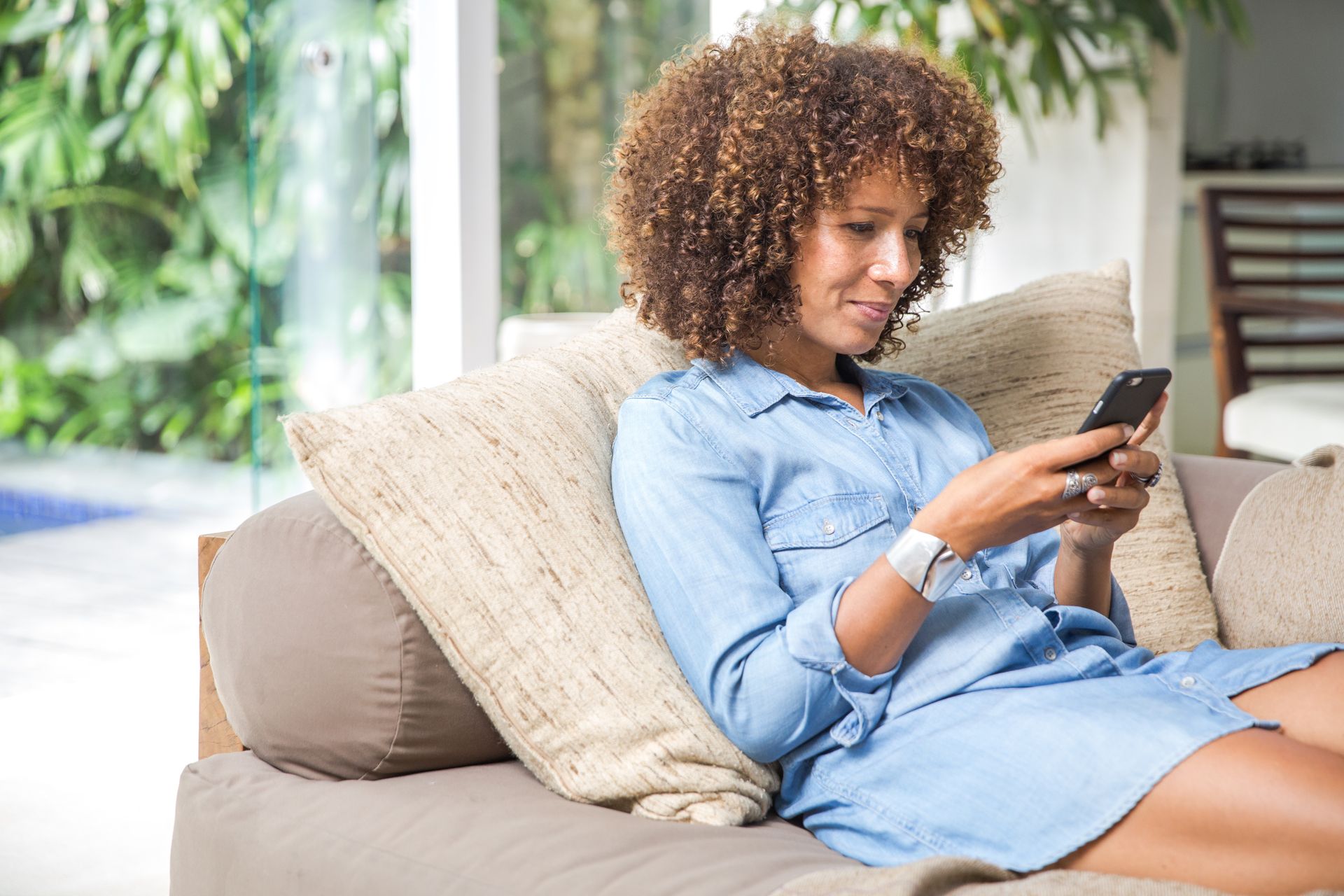 A woman is sitting on a couch looking at her cell phone at The Winchester