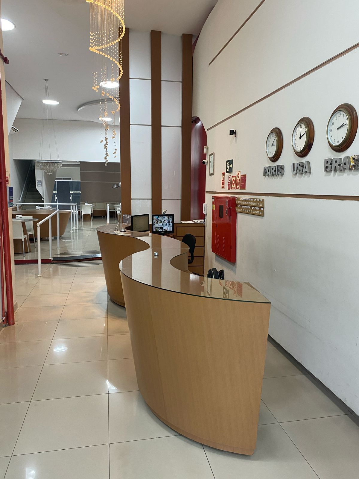 Um lobby com relógios na parede e um balcão de madeira