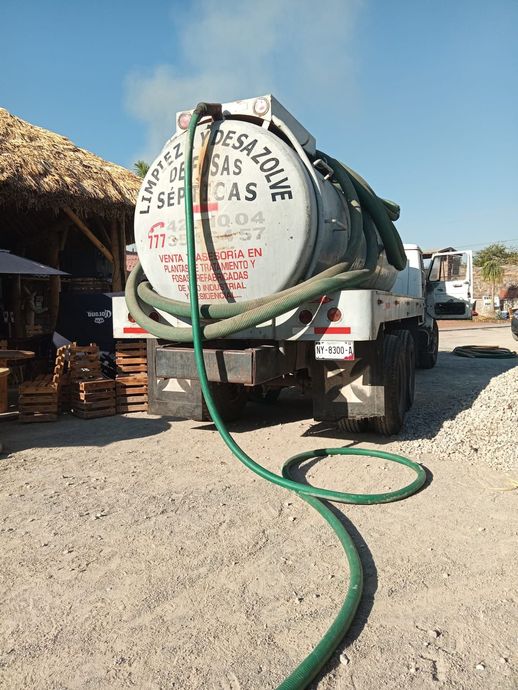 Camión blanco con un tanque rotulado 