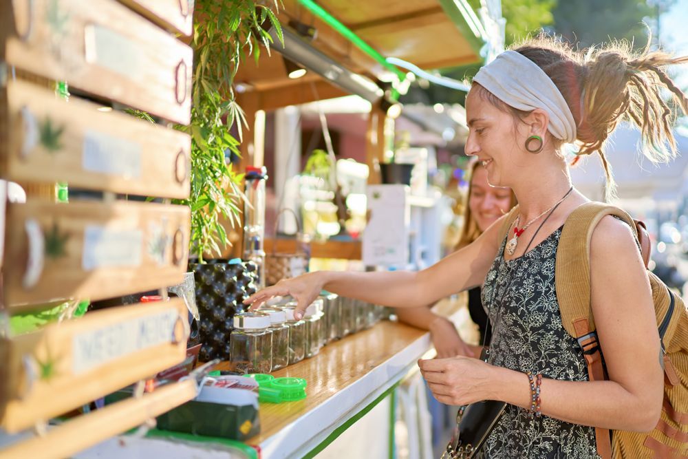 A woman is standing in front of a food truck at a market.