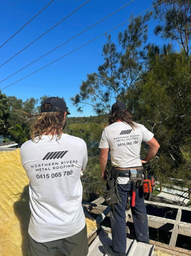 Two Men Are Standing on Top of a Wooden Structure — Northern Rivers Metal Roofing PTY LTD In Ewingsdale, NSW