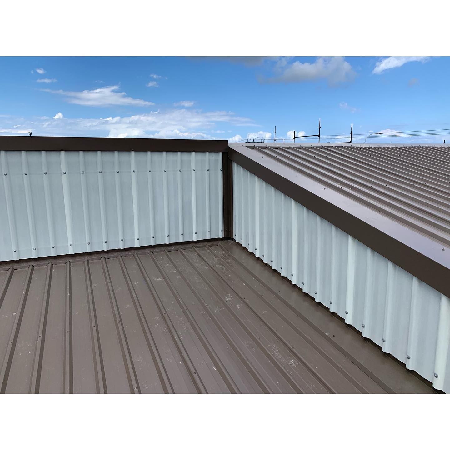 A Brown and White Metal Roof With a Blue Sky in the Background — Northern Rivers Metal Roofing PTY LTD In Kingscliff, NSW