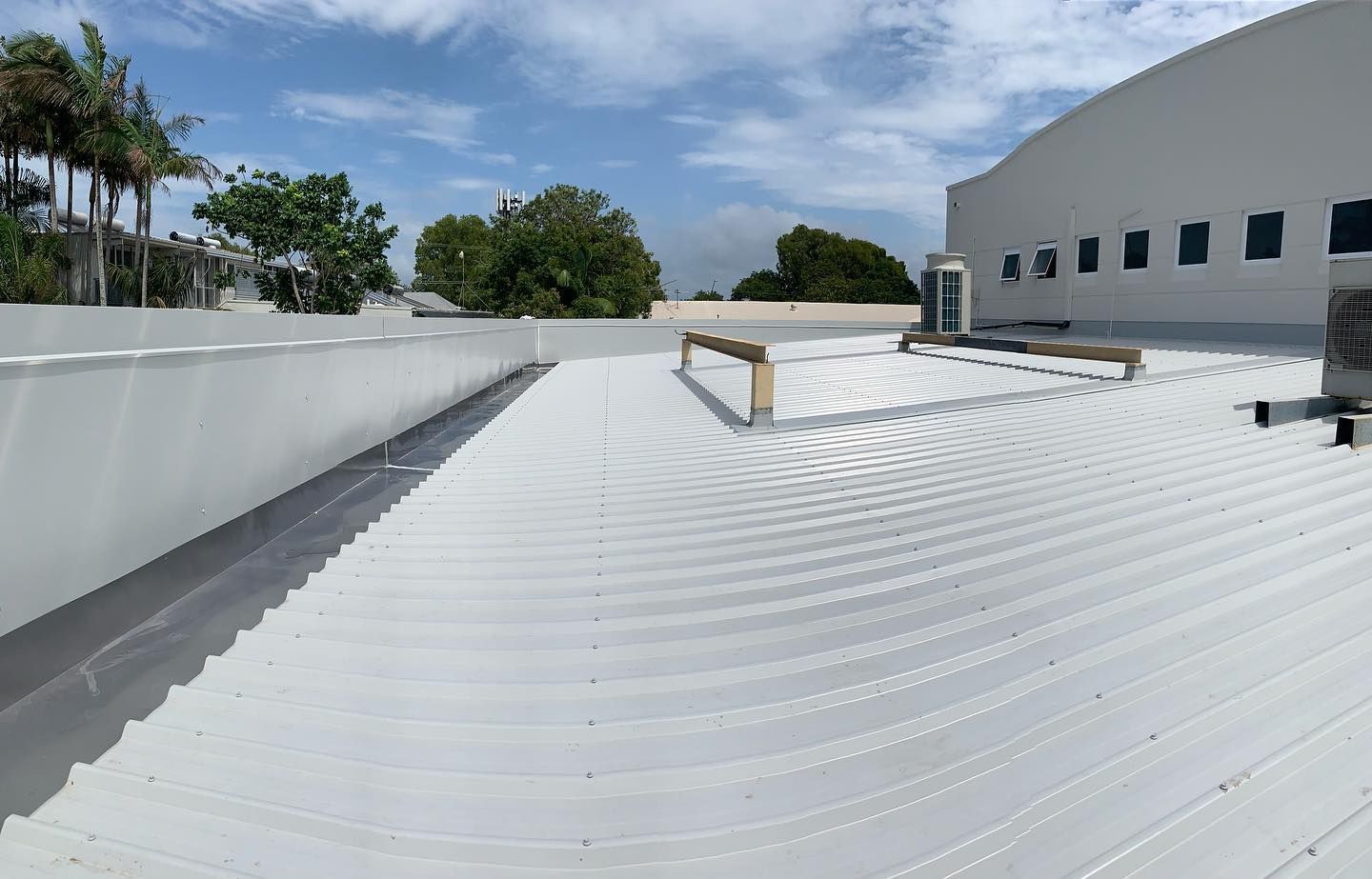 A White Roof of a Building With Trees in the Background — Northern Rivers Metal Roofing PTY LTD In Alstonville, NSW