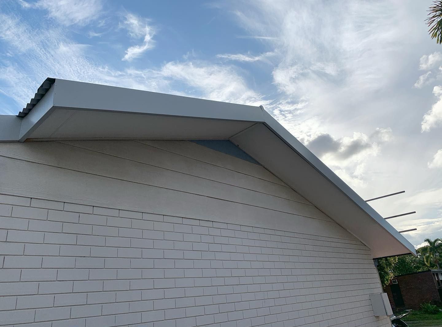 A White Brick Building With a White Roof — Northern Rivers Metal Roofing PTY LTD In Ewingsdale, NSW