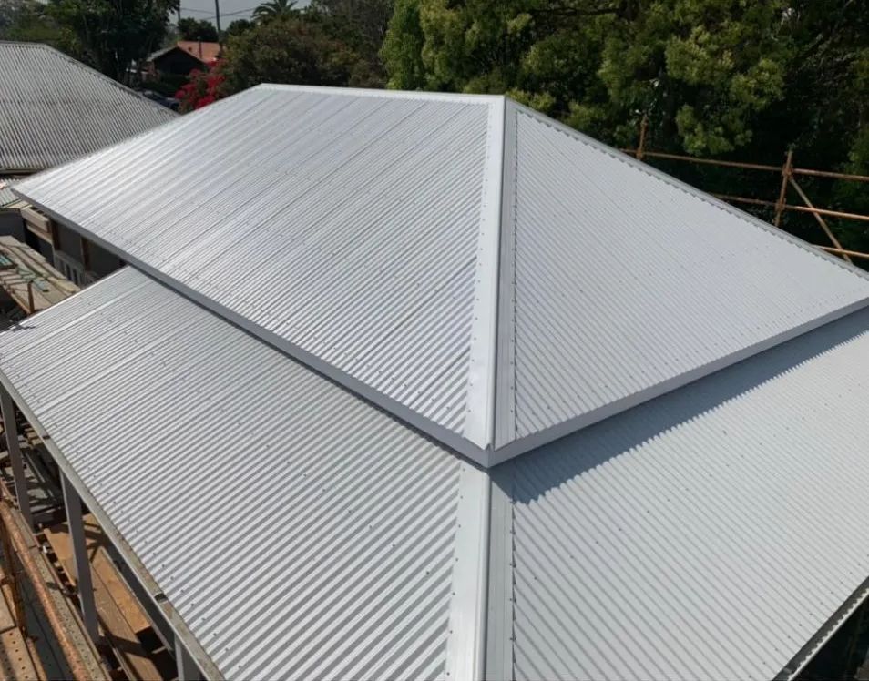 A White Corrugated Metal Roof is Being Installed on a House — Northern Rivers Metal Roofing PTY LTD In Ewingsdale, NSW