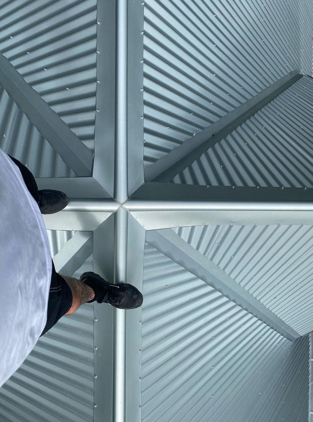 A Person is Standing in the Corner of a Building — Northern Rivers Metal Roofing PTY LTD In Kingscliff, NSW