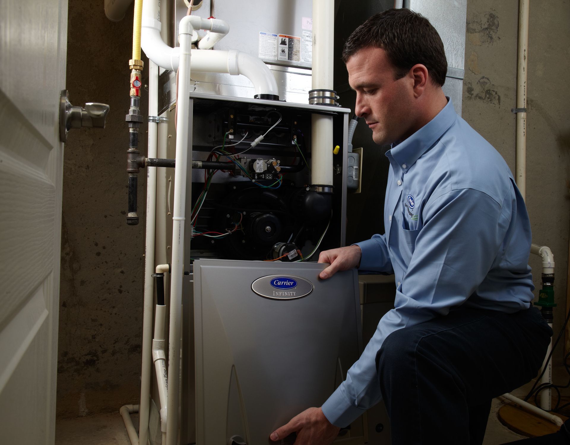 A man in a blue shirt is working on an air conditioner