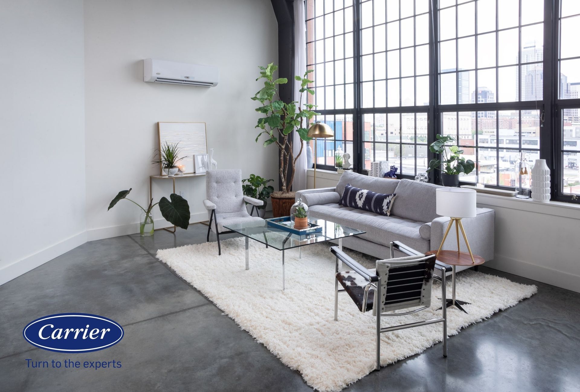 A living room with a couch and chairs and a carrier logo