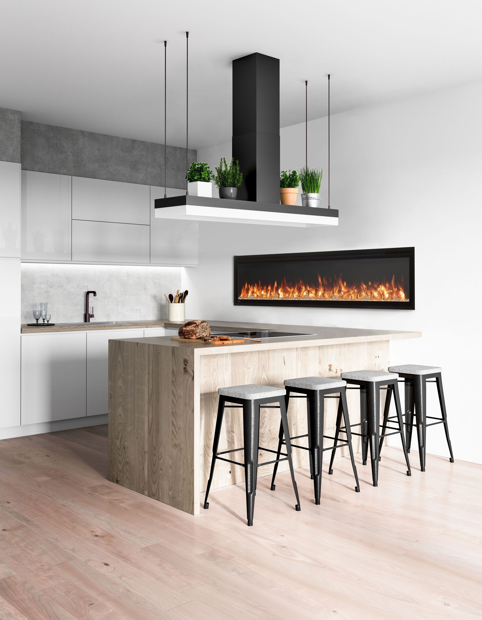 Modern kitchen with island, fireplace, and black stools. White walls, wood floor, and plant decor.