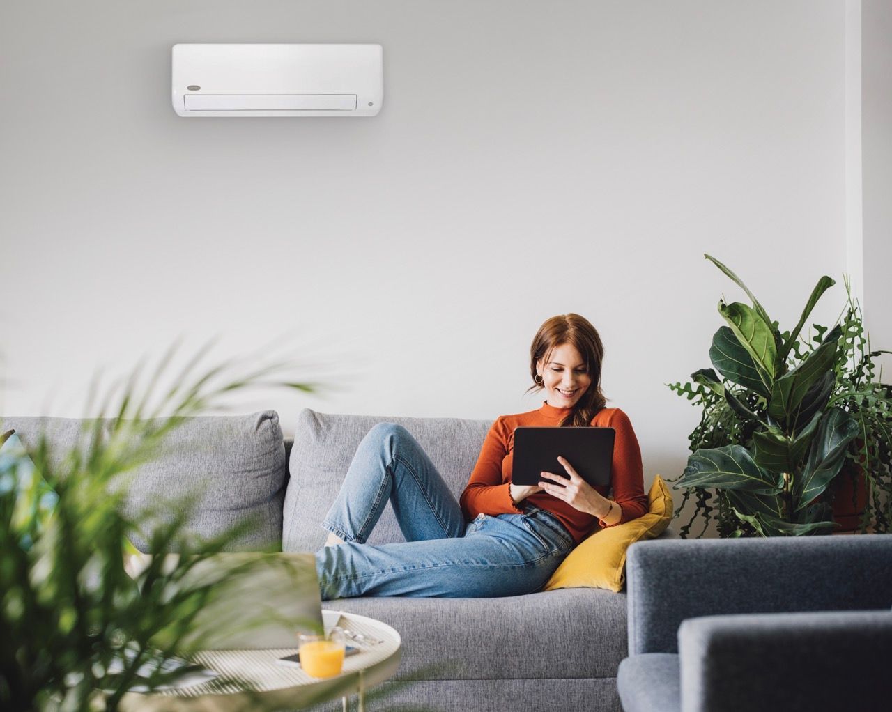 A man is adjusting a thermostat on a wall.