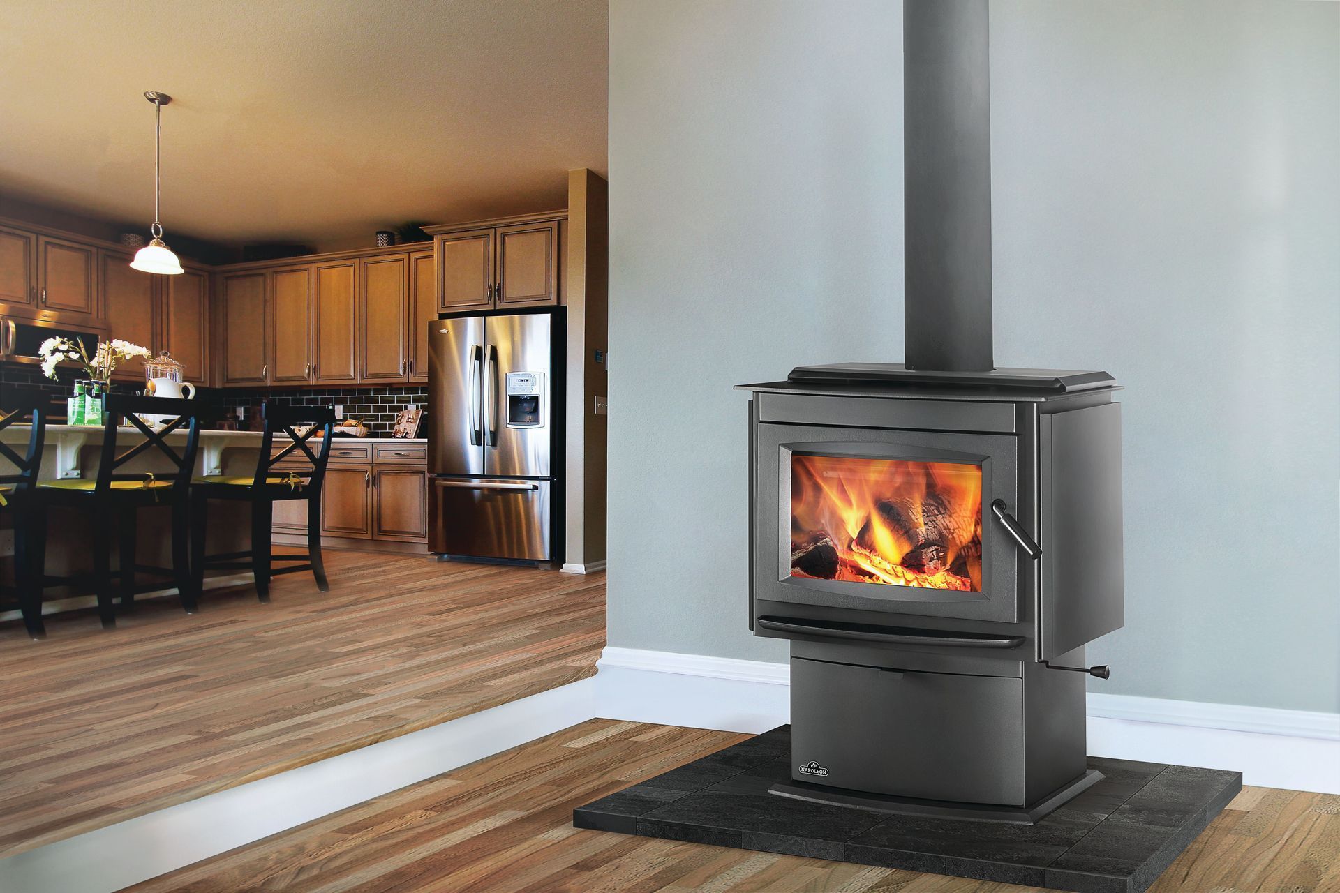 A wood stove is sitting in a room next to a pile of logs.