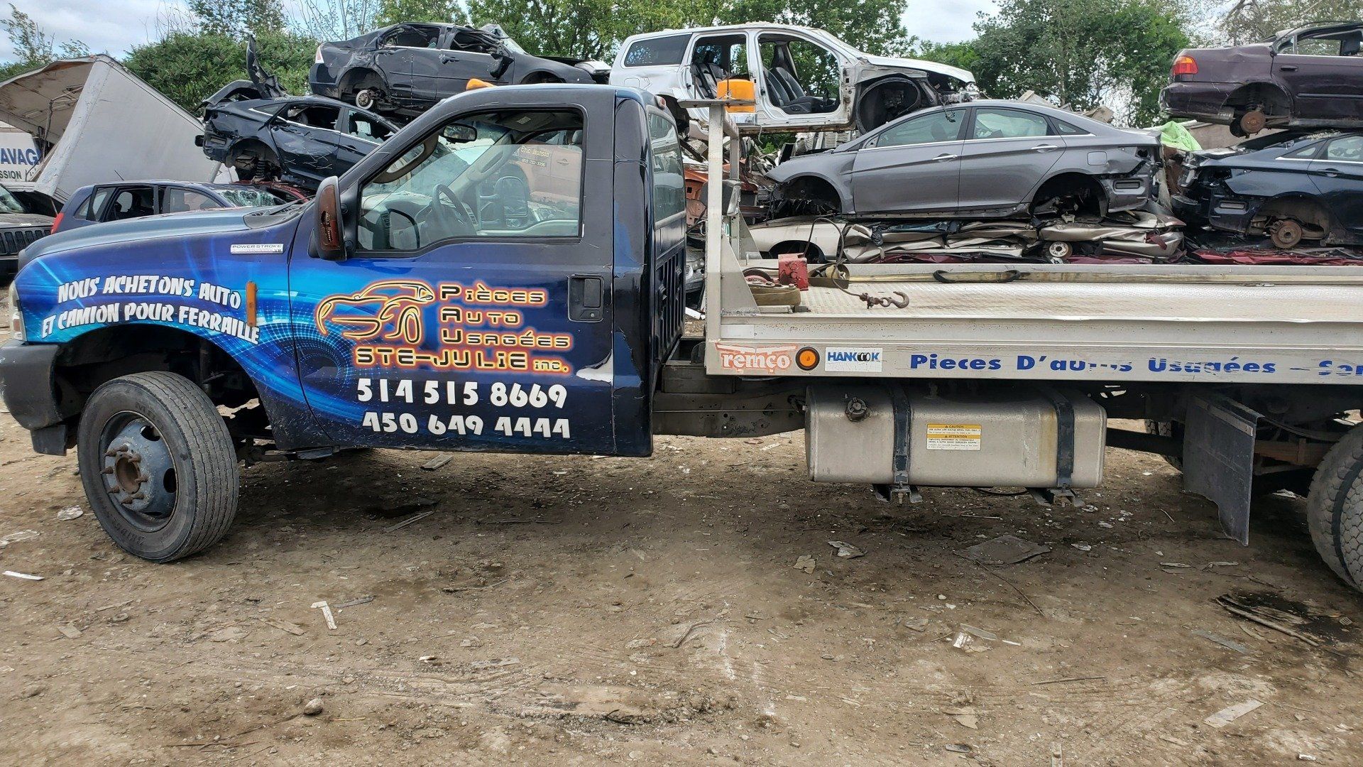 Une dépanneuse est garée dans une pile de voitures.
