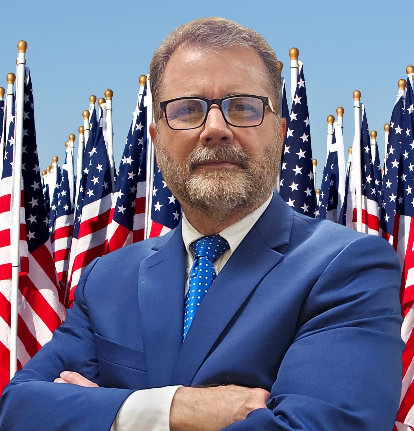 A man with a beard and glasses is wearing a suit and tie.