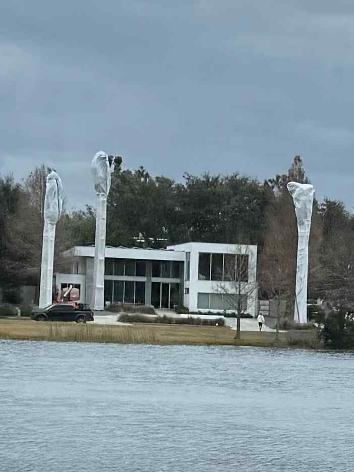 A tree trimming operation; a cherry picker reaches into a tree.