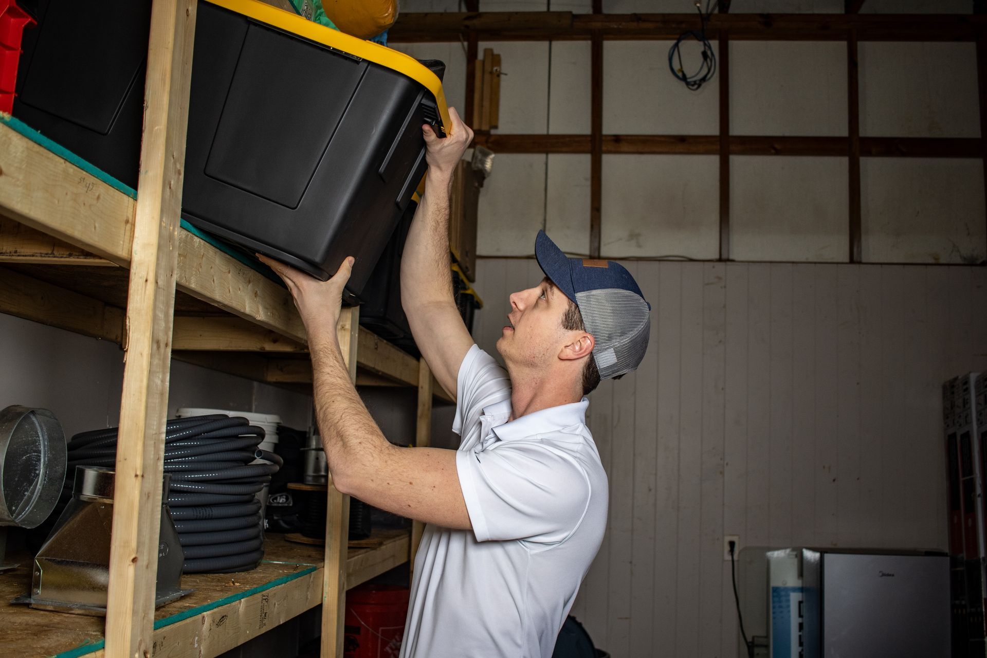 A woman is using a remote control to turn on the air conditioner.