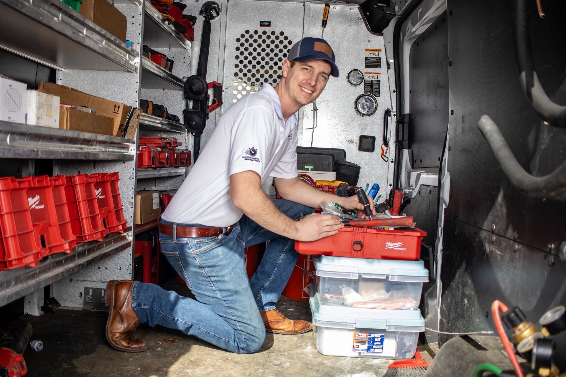 Two men are working on an air conditioner outside of a building.