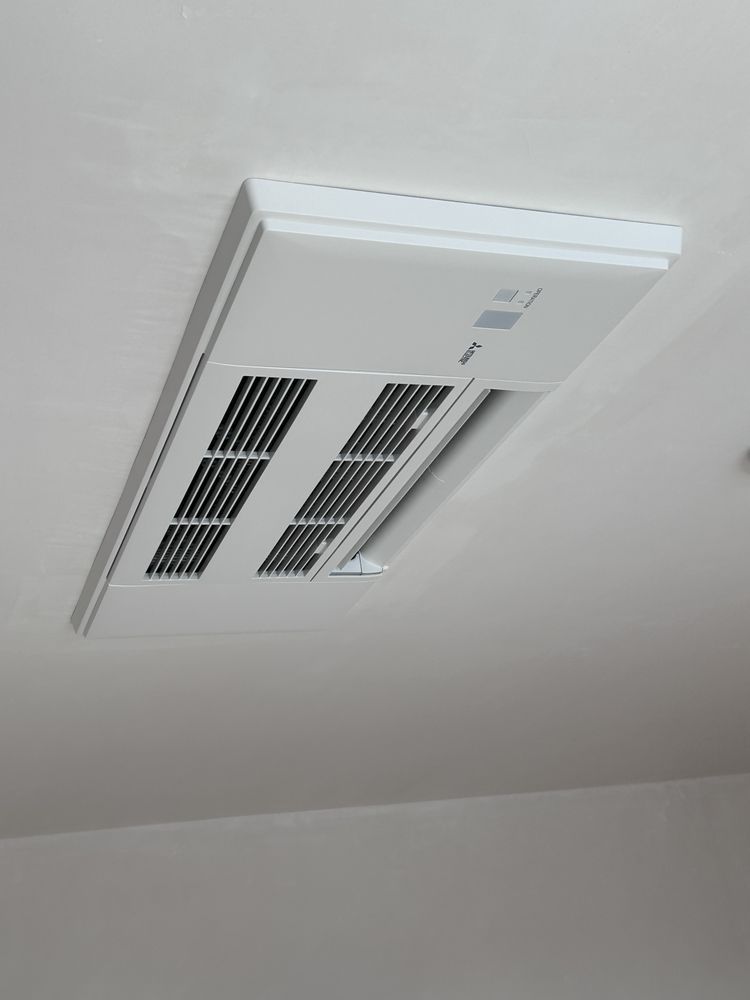 White rectangular ceiling air vent with multiple black grates.