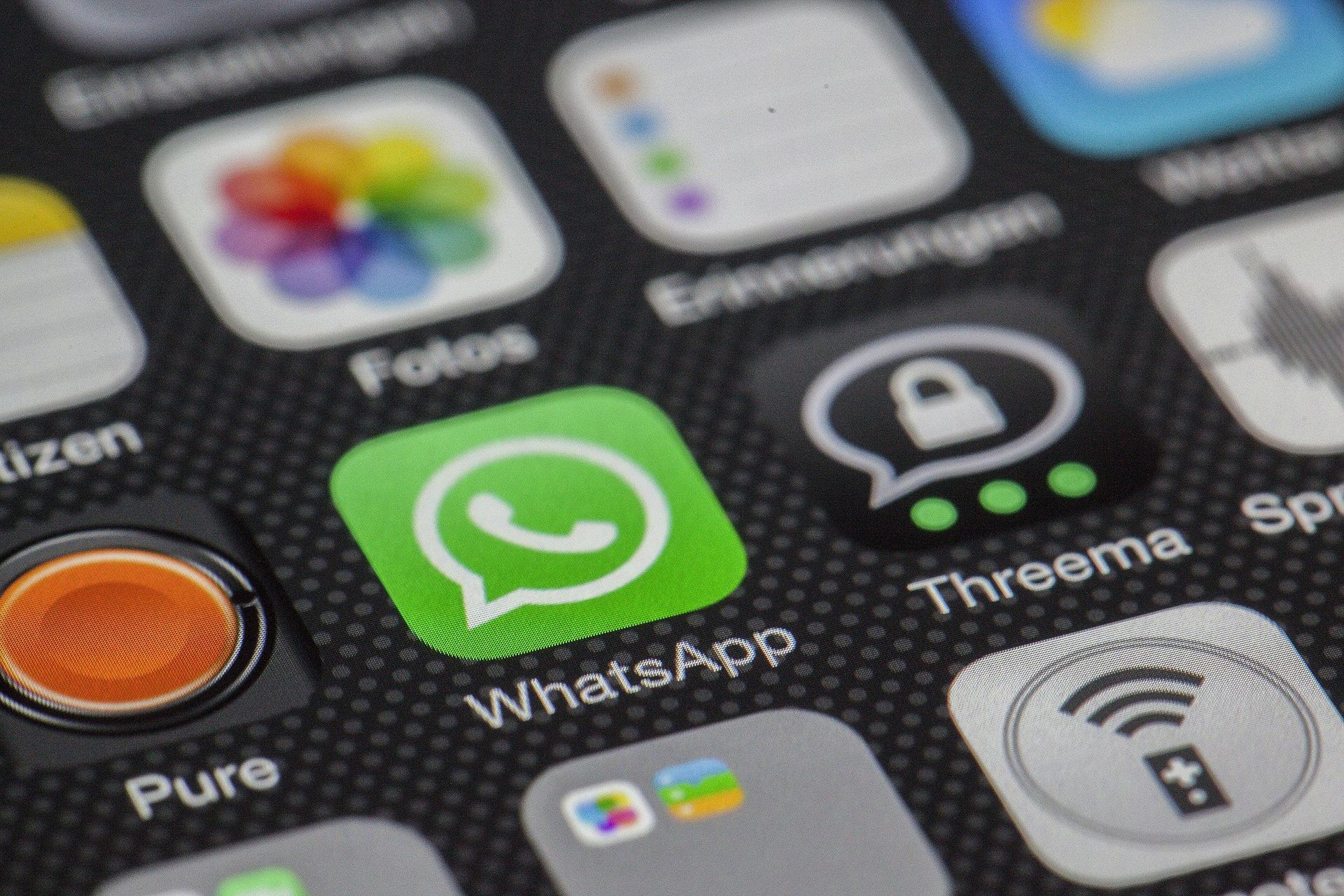 Close-up of a smartphone screen showing the WhatsApp app icon surrounded by other app icons.