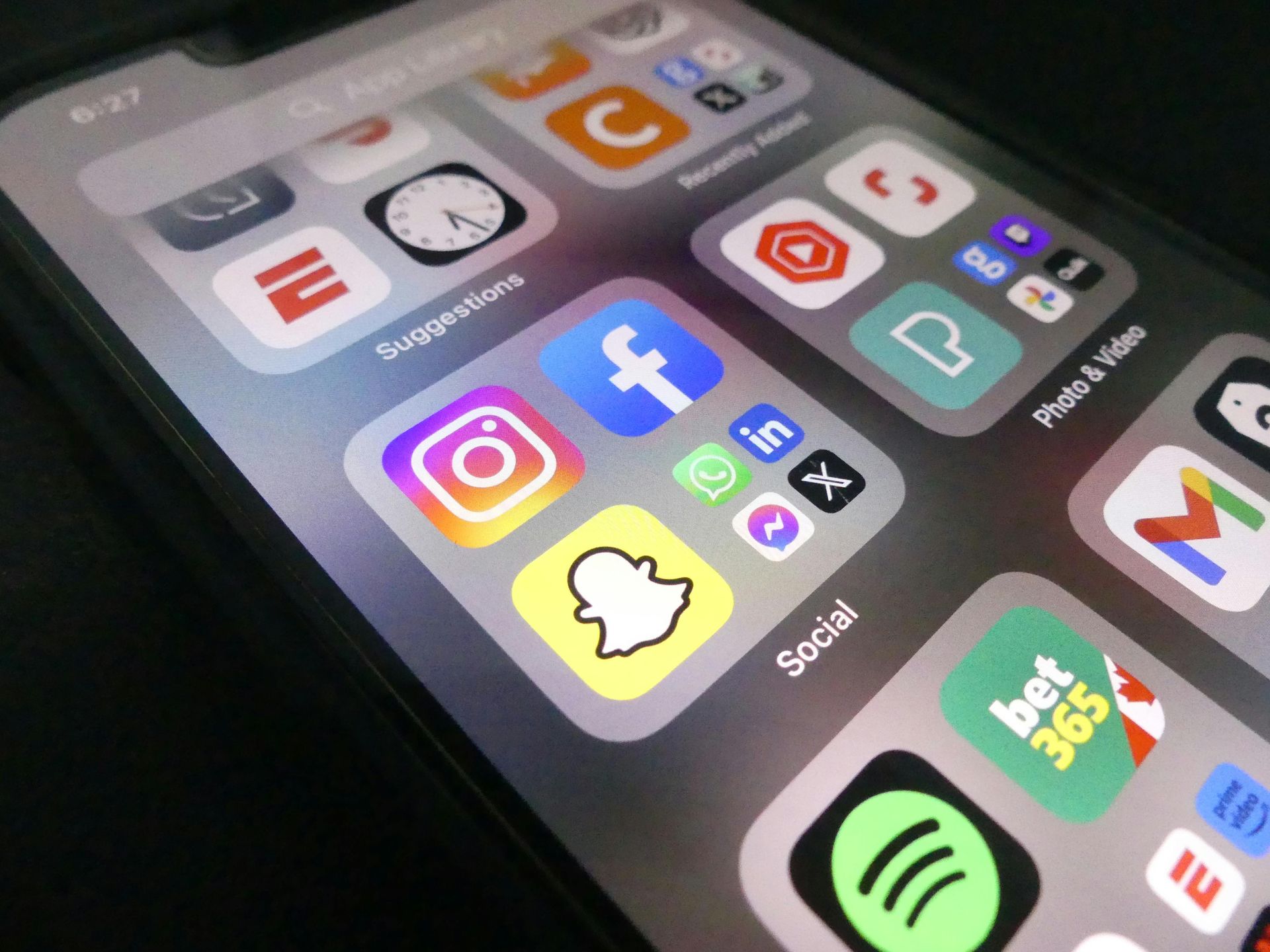 Smartphone home screen with social media app icons, including Instagram, Facebook, and Snapchat.