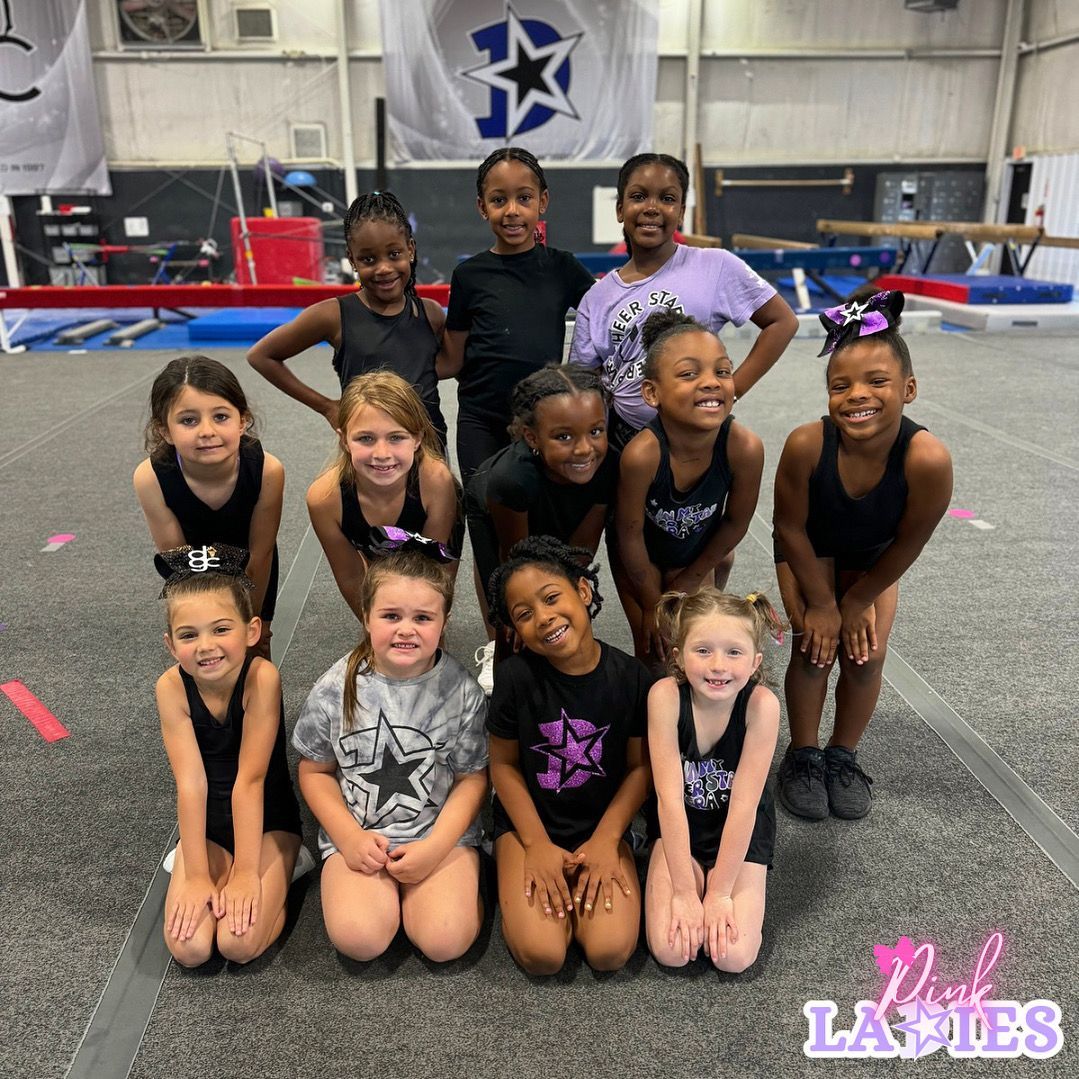A group of young girls are posing for a picture in a gym.