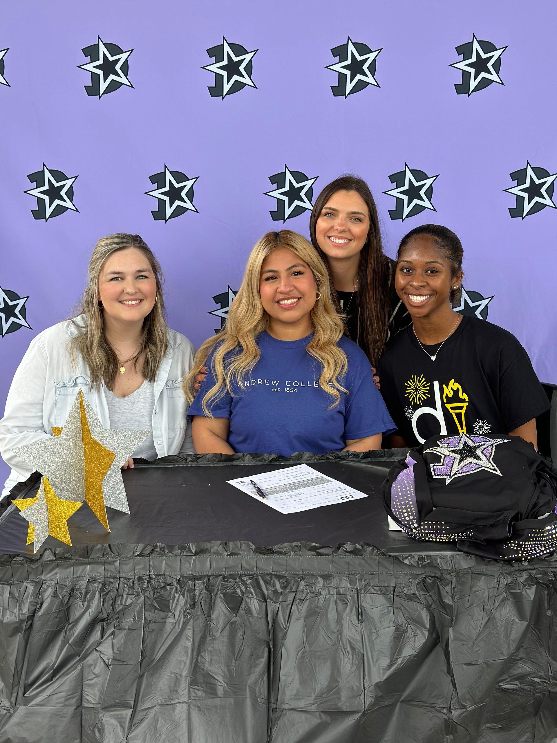 A group of women are posing for a picture while sitting at a table.