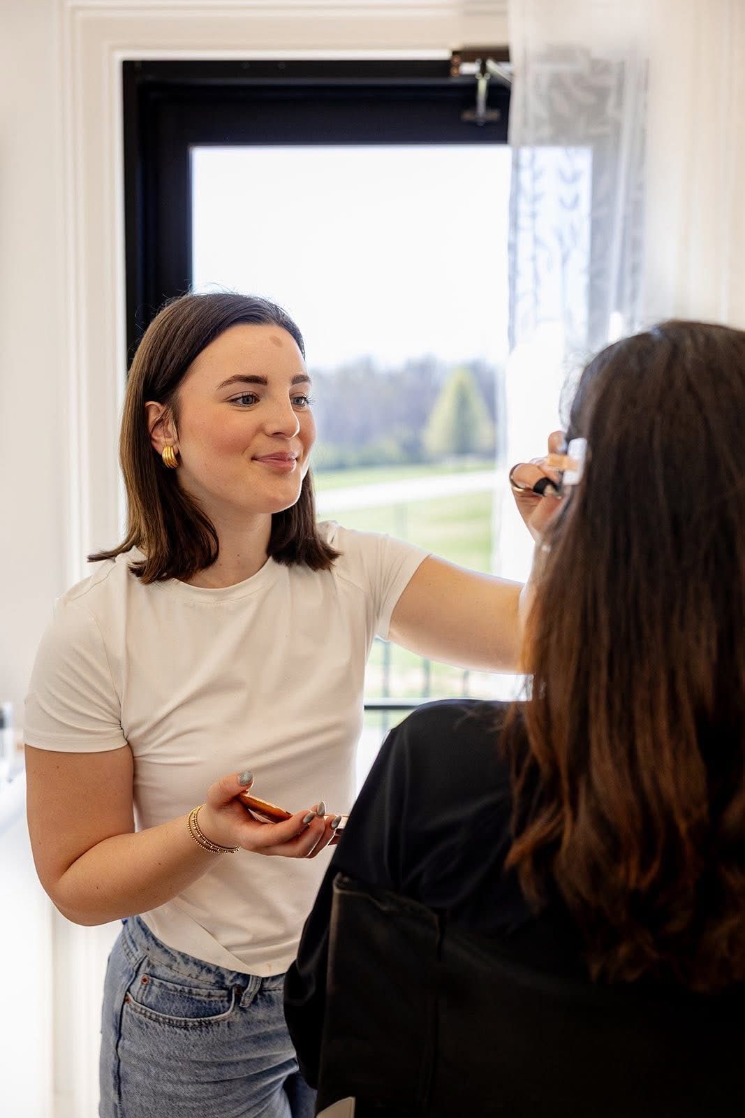 A woman in a purple shirt is sitting in a blue chair holding a comb