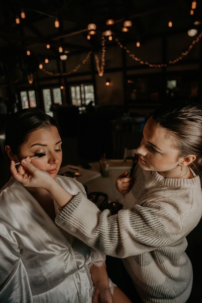 A woman is applying makeup to another woman 's face.