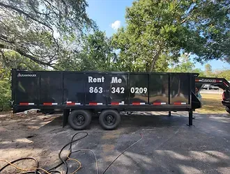 A dumpster trailer is parked on the side of the road.