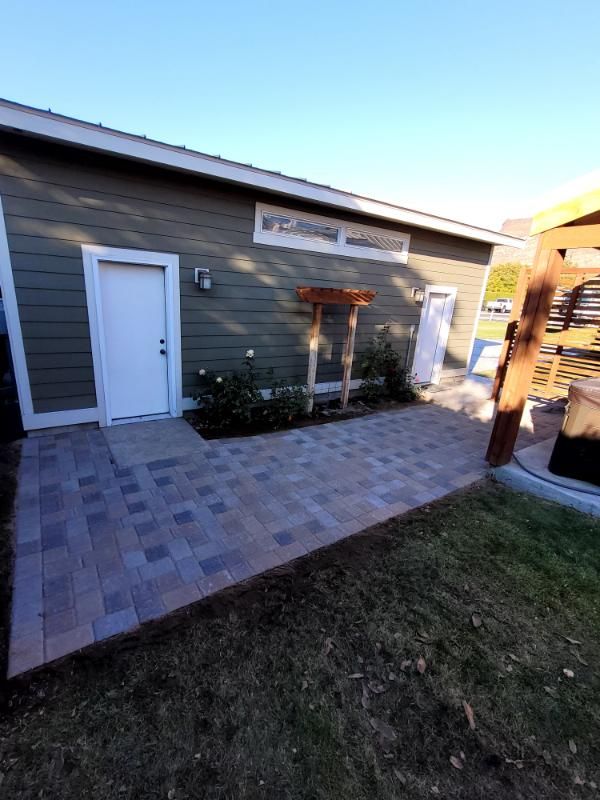 A house with a white door and a patio in front of it.