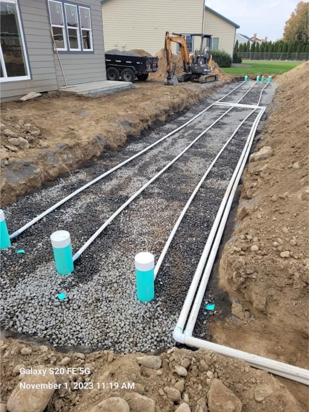 A drainage system is being installed in the backyard of a house.
