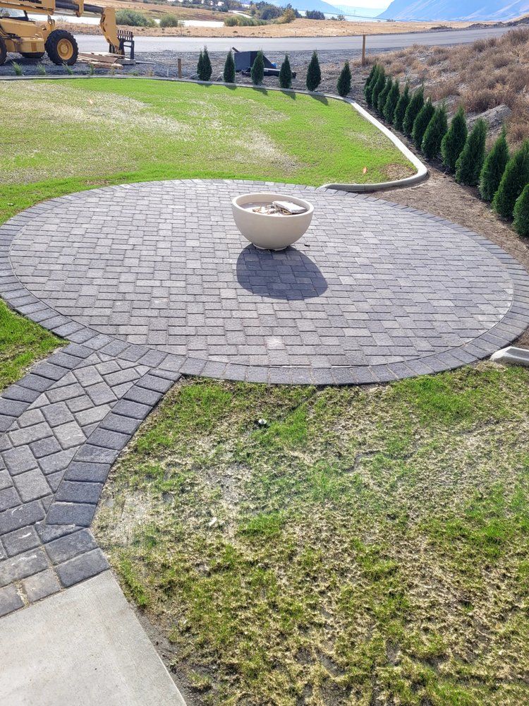 A brick patio with a pot in the middle of it