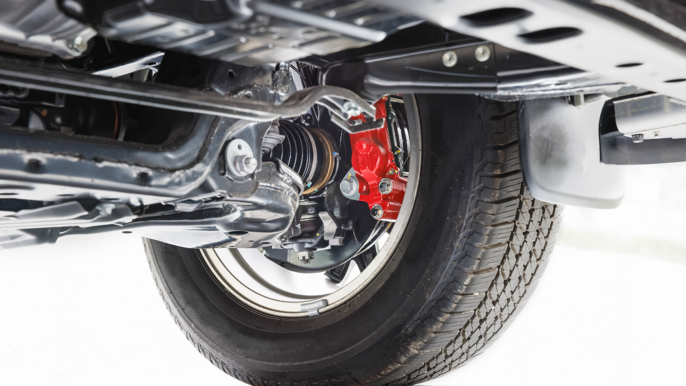 Underside view of a car wheel, showing a red brake caliper, suspension components, and the tire.