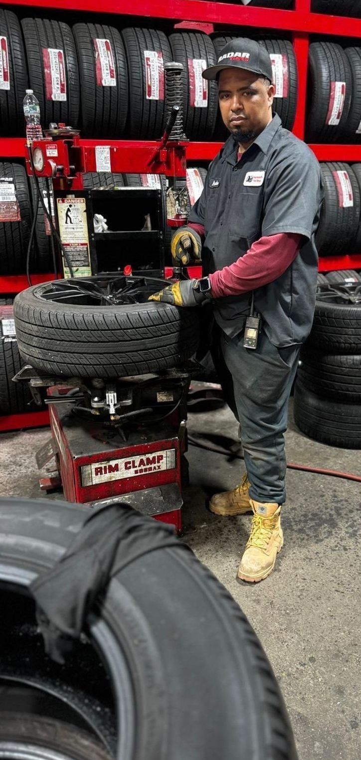 A man is working on a tire in a tire shop.