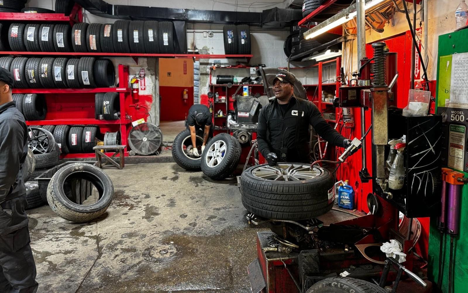 A man is working on a tire in a tire shop.