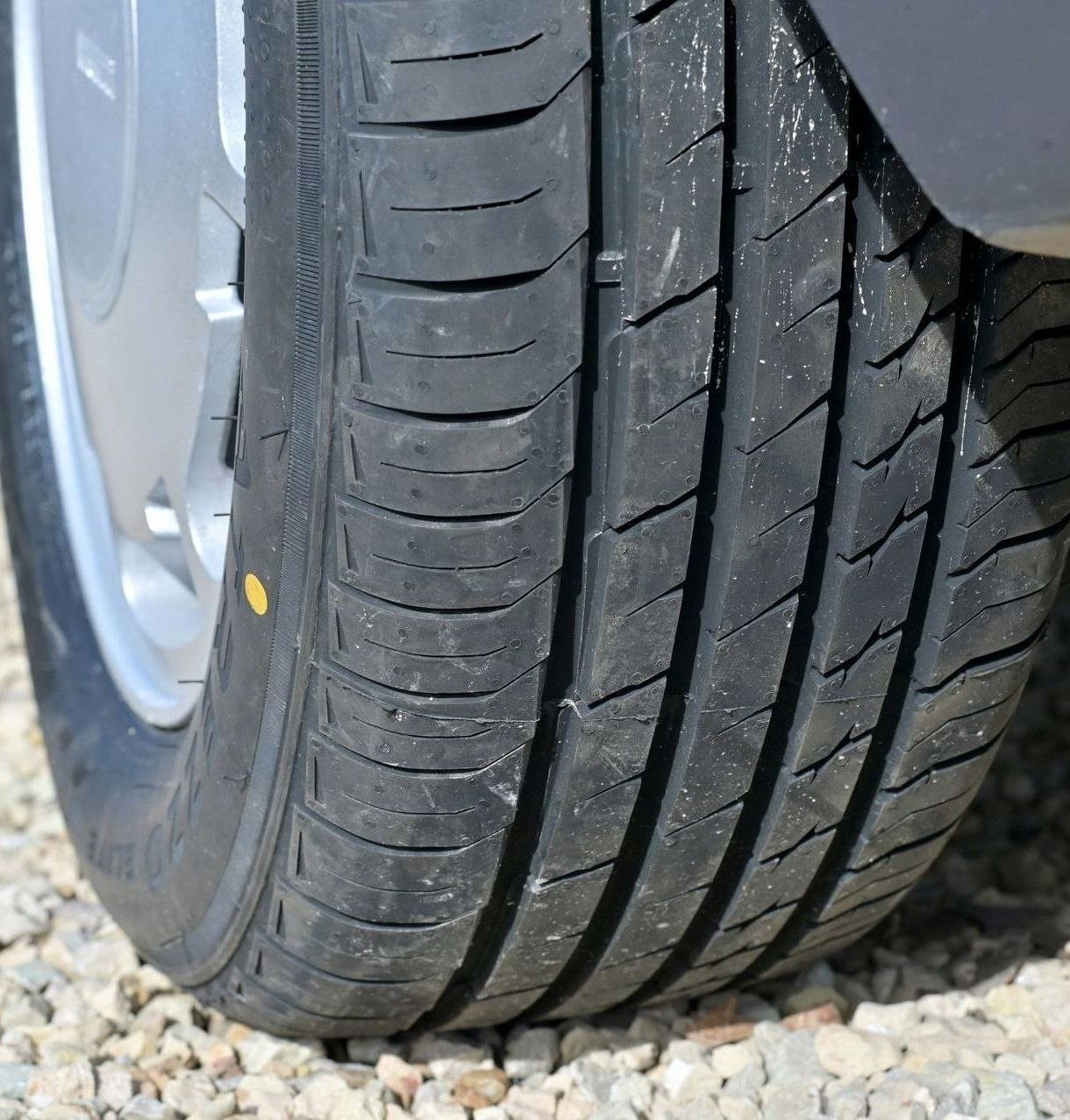 A close up of a tire on a gravel road
