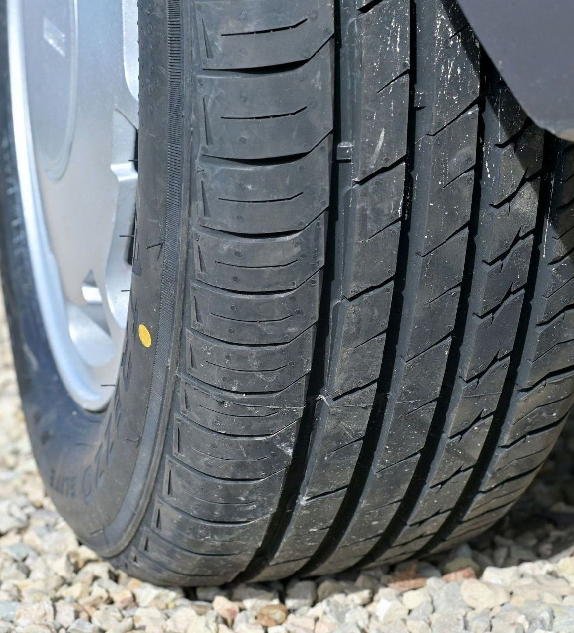 A close up of a tire on a gravel road