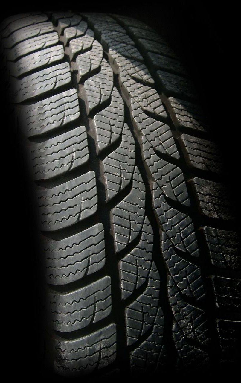 A close up of a tire on a black background