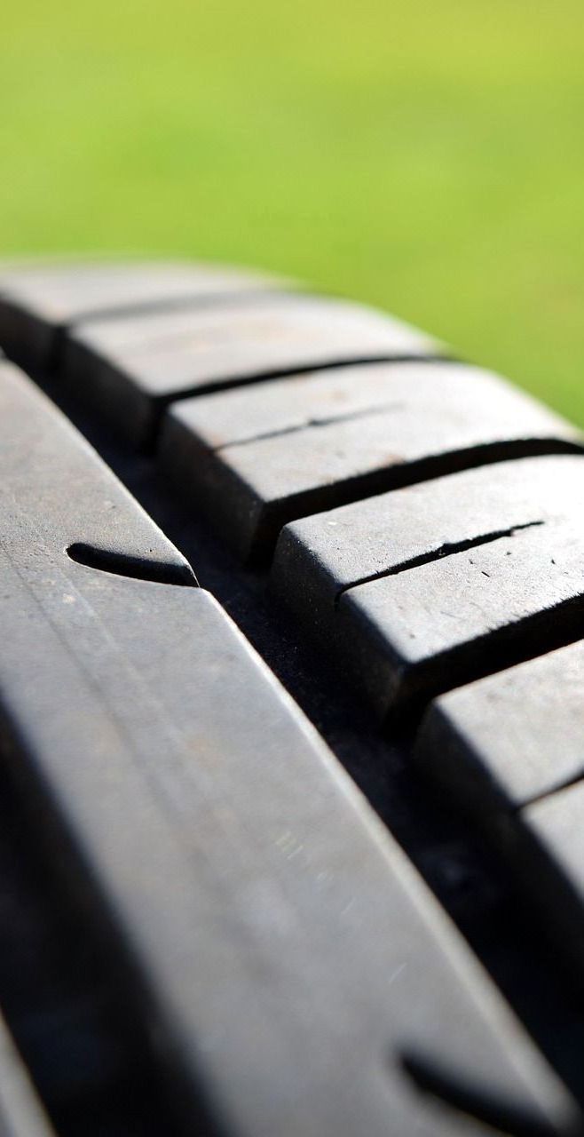 A close up of a tire with a green background